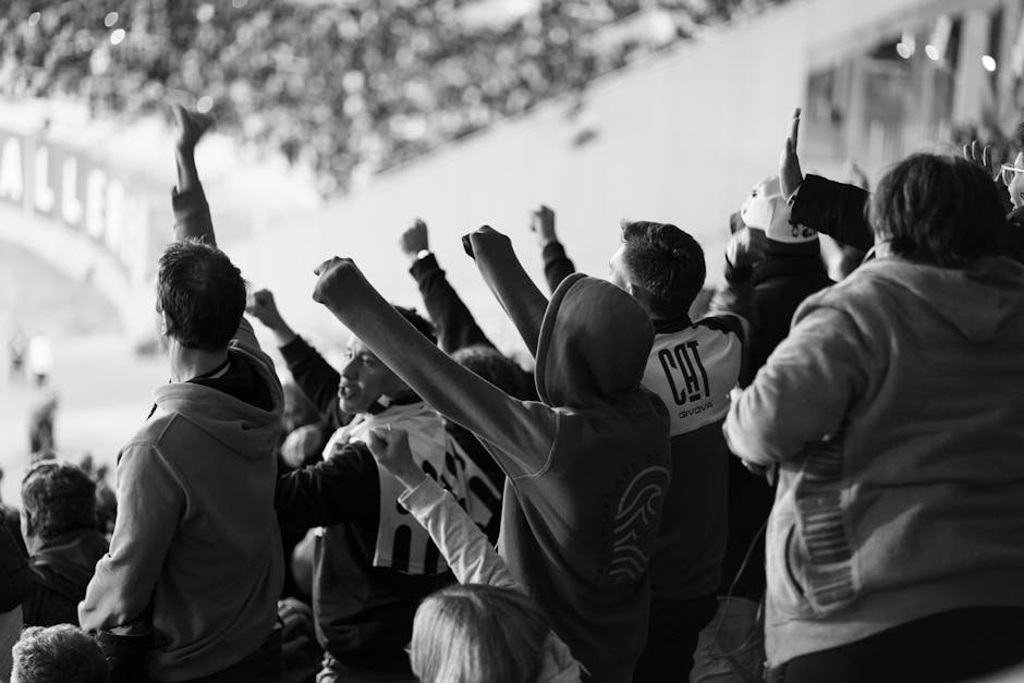 A crowd of enthusiastic football fans cheering inside a stadium in CΓ³rdoba, Argentina.