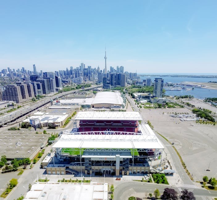 A vibrant aerial view of BMO Field with the Toronto skyline and CN Tower in the background.