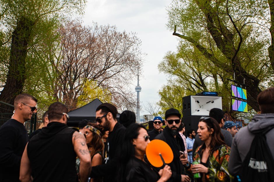 Vibrant outdoor group gathering near CN Tower in Toronto, daytime setting.
